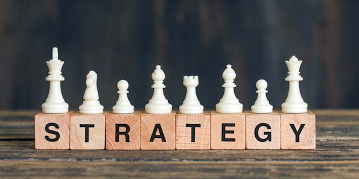 مهره‌های سفید شطرنج چیده شده بر روی بلوک‌های چوبی که کلمه "STRATEGY" را تشکیل می‌دهند. این تصویر می‌تواند نمایانگر اهمیت برنامه‌ریزی، تعیین اهداف و اتخاذ استراتژی‌های مناسب برای مدیریت چالش‌های نگارش پایان نامه و پیشبرد موفقیت‌آمیز آن باشد. تفکر استراتژیک در مواجهه با موانع و یافتن راهکارهای مؤثر در این تصویر تداعی می‌شود.
